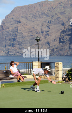 I turisti si vede durante un gioco di bocce a Los Gigantes Tenerife Isole Canarie in background le famose Scogliere Foto Stock