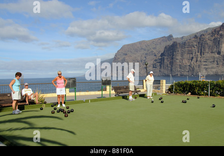 I turisti si vede durante un gioco di bocce a Los Gigantes Tenerife Isole Canarie in background le famose Scogliere Foto Stock