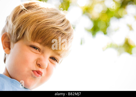 Little Boy rendendo silly volti all'aperto Foto Stock