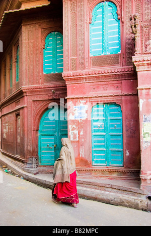 Donna cammina passato esterno di un Haveli Bikaner Rajasthan in India Foto Stock