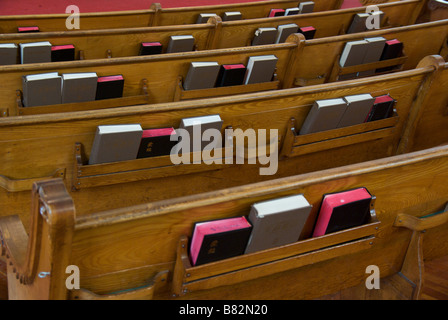 Il retro del banco di legno sedie in una vecchia cattedrale chiesa di tipo cinese con la Bibbia e inno libro in tasca fessura Foto Stock