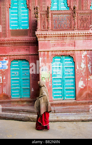 Donna cammina passato esterno di un Haveli Bikaner Rajasthan in India Foto Stock