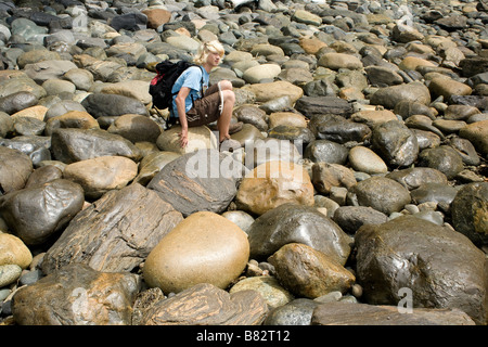 BRITISH COLUMBIA - escursionista in appoggio sui massi arrotondati lungo il Juan de Fuca sentiero marino a Sombrio Beach. Foto Stock