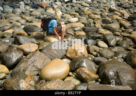 BRITISH COLUMBIA escursionista in appoggio sui massi arrotondati lungo il Juan de Fuca sentiero marino a Sombrio Beach. Foto Stock