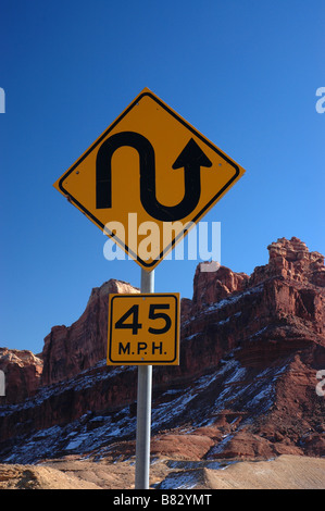 Un ventoso cartello stradale attraverso il lupo maculato canyon dello Utah, vicino San Raffaello si gonfiano. Foto Stock