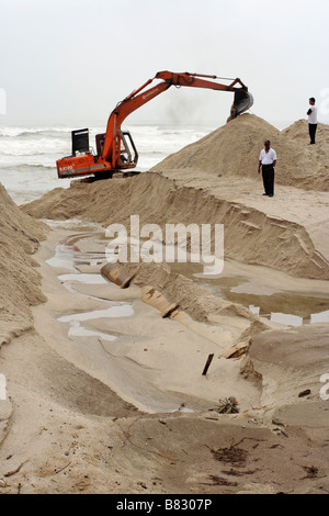 Un escavatore lavorando sulla spiaggia sabbiosa a Kuala Terengganu, Malaysia. Foto Stock