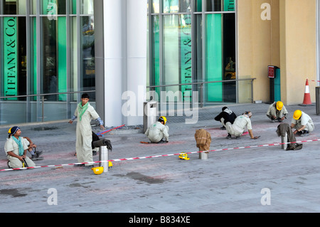 Gruppo di lavoratori che mettono il tocco finale alla pavimentazione esterna Negozi Tiffany nel Dubai Mall, centro commerciale, United Arab Emirati Arabi Uniti Foto Stock