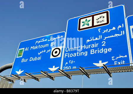 Dubai blu autostrada bilingue uscita uscita destinazione indicazione del percorso Sul portale sopra il traffico una giornata di sole United Arab Emirati Arabi Uniti Medio Oriente Foto Stock