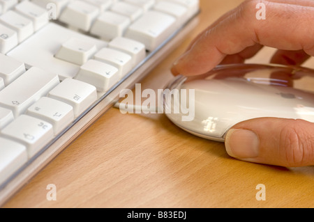 Uomo che usa il mouse e la tastiera del computer si chiudono Foto Stock