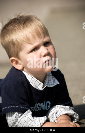 Bionda caucasica Ragazzo che guarda pensieroso. Foto Stock