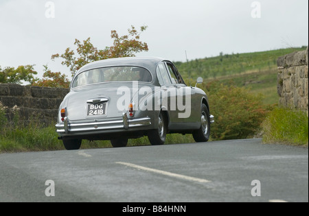 Jaguar Mk2 automobili la curva su una strada di campagna Foto Stock