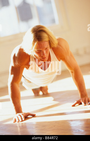 Giovane uomo la preformatura push up esercizio in palestra Foto Stock