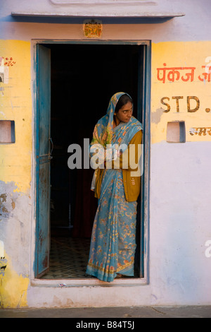 Local donna indiana sta nella porta Bikaner Rajasthan in India Foto Stock