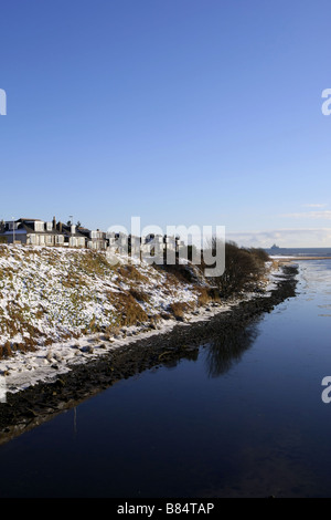 Case a Donmouth accanto al Fiume Don nella città di Aberdeen, Scozia, Regno Unito durante il periodo invernale con neve sulle rive del fiume. Foto Stock