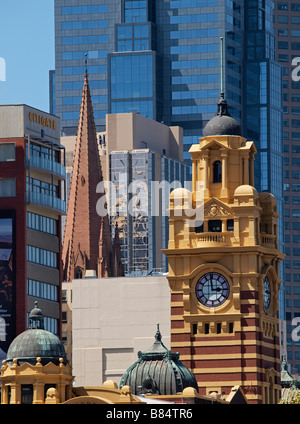 La torre dell'orologio di Flinders Street stazione ferroviaria con la città sullo sfondo di edifici Melbourne Victoria Australia Foto Stock