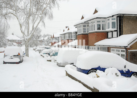 Case e automobili nel sud-ovest sobborgo londinese coperto di neve, Sutton, Londra Sud, Surrey, Inghilterra Foto Stock