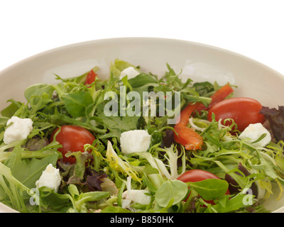 Fresco e salutare Insalata mista con formaggio Feta servita su una piastra isolata contro uno sfondo bianco con nessun popolo e un tracciato di ritaglio Foto Stock