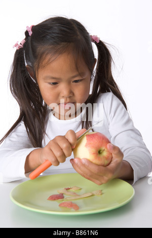 Bambina bucce è una mela con un coltello Foto Stock