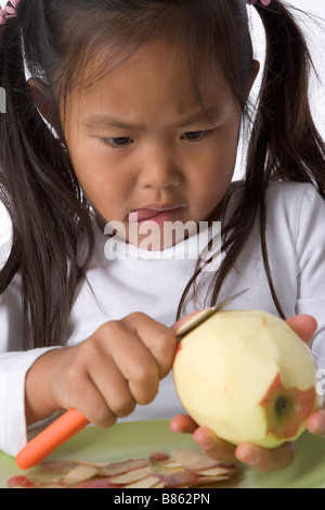 Bambina bucce è una mela con un coltello Foto Stock