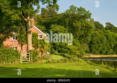 Mattone rosso Cottage e il fiume Wye sopra Glasbury in Powys Foto Stock