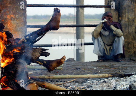 Il corpo è la masterizzazione su una pira funeraria su un ghat lungo il fiume Gange nella città santa di Varanasi in India Foto Stock