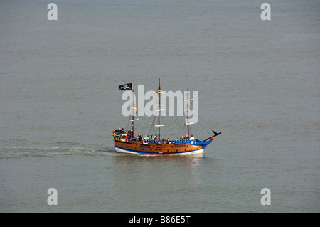 Battello turistico a tema pirata che batte una bandiera nera di Jolly Roger. South Bay. Scarborough. North Yorkshire. REGNO UNITO Foto Stock