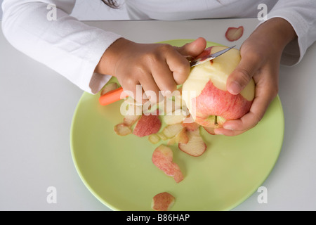 Bambina bucce è una mela con un coltello Foto Stock