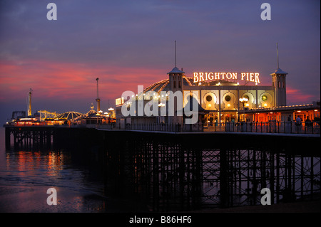 Il Brighton Pier al tramonto con la vita notturna solo all'inizio. Foto da Jim Holden. Foto Stock