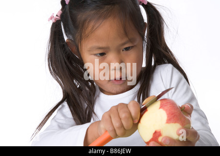 Bambina bucce è una mela con un coltello Foto Stock