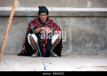 Un uomo si siede nella strada Tarabuco Bolivia Foto Stock