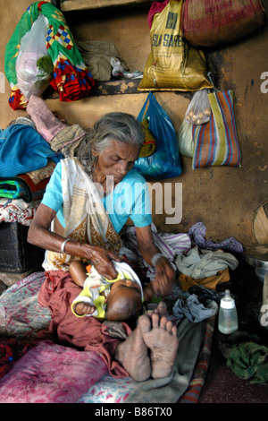 Una vecchia donna si siede con un bambino in una casa per persone anziane che sono venuti per la città santa di Varanasi in India per attendere di morire Foto Stock
