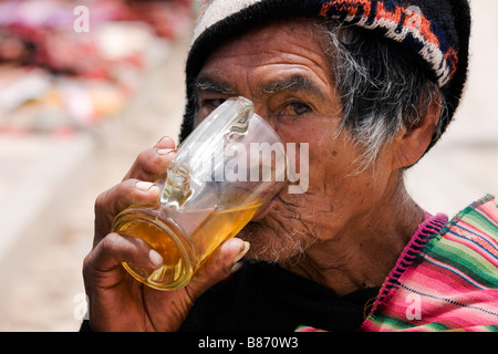 Un anziano uomo locale beve succo di frutta nel villaggio di Tarabuco Bolivia Foto Stock