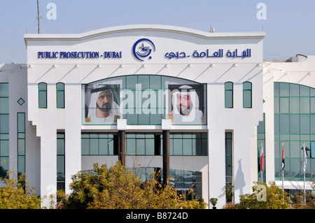 Cartelli bilingue Emirati Arabi Uniti negli Emirati Arabi Uniti sopra la parte anteriore façade & Ingresso del governo di Dubai pubblico ministero edificio maschile ritratti & vetro colorato Foto Stock