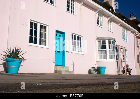 Signora Lettura da casa rosa sul lungomare di Lyme Regis Foto Stock