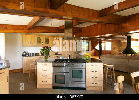 Cucina a pianta aperta con bar per la colazione e travi in legno con vista attraverso a soggiorno Foto Stock