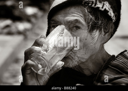 Un anziano uomo locale beve succo di frutta nel villaggio di Tarabuco Bolivia Foto Stock