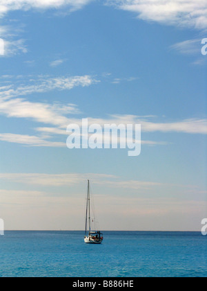 Lone barca a vela sul mare calmo, cielo blu, Olu Deniz, Turchia Foto Stock