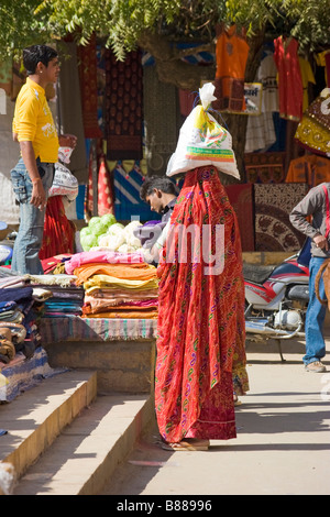 Donna indiana porta sacco in testa nel mercato Jaisalmer Rajasthan in India Foto Stock