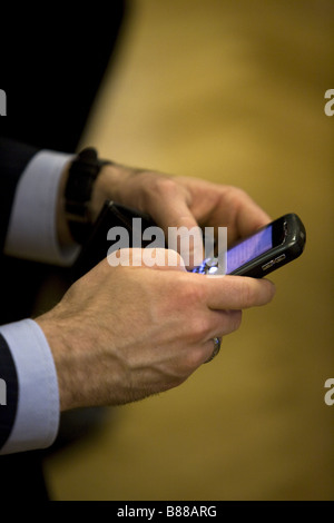 Imprenditore della messaggistica di testo dal proprio telefono Blackberry Foto Stock