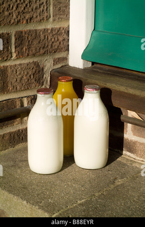 Bottiglie di latte sul gradino della porta Foto Stock