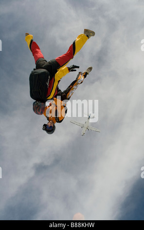 Skydivers sono battenti a testa in giù e la tenuta di ciascun altro. In questa posizione di freefly il team potrà ottenere una elevata velocità di caduta libera. Foto Stock