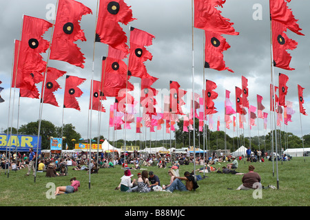 Glastonbury Festival ventole e i frequentatori del festival sedersi e rilassarsi tra le grandi bandiere a Glastonbury Giugno 2008 Foto Stock