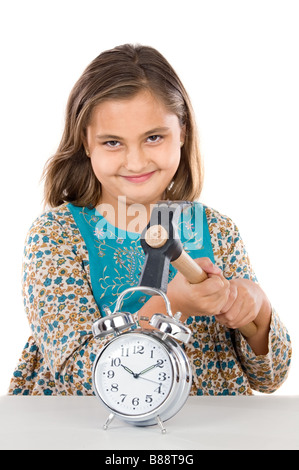 Bellissima ragazza con orologio e un martello su sfondo bianco Foto Stock