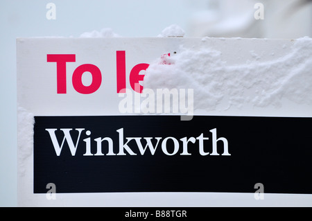 Agenti immobiliari Winkworth House per lasciare schede ricoperte di neve in inverno Foto Stock