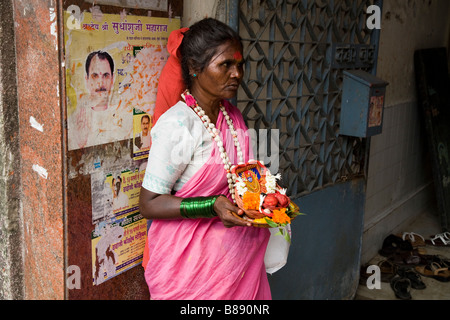 Le donne a un tempio ingresso offerte di vendita di Le calendule (puja o pooja o toran) e cibo per gli dèi. Mumbai, India. Foto Stock