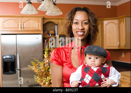 African American donna pone con suo Figlio bambino nel rinnovato cucina moderna Foto Stock