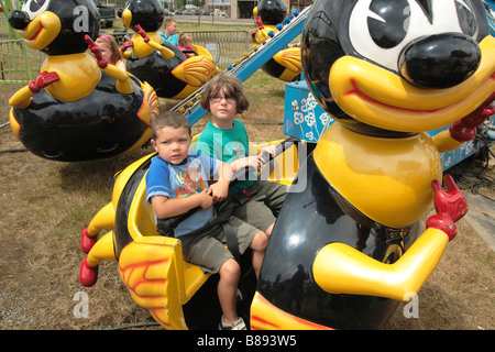 Due bambini in un giro di divertimento alla fiera della contea Foto Stock