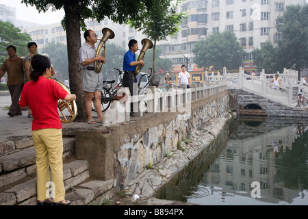 Fanfara ripassando a Lakeside pier nelle prime ore del mattino in Kaifeng, antica capitale della dinastia Song, Cina. Foto Stock