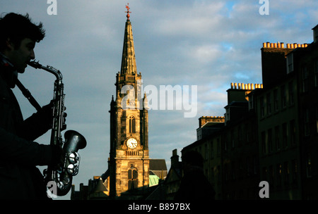 Un suonatore ambulante stagliano svolge un sassofono sul Royal Mile vicino Tron Kirk in Scozia Edimburgo REGNO UNITO Foto Stock