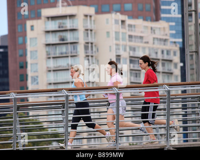 Tre donne corrono in passerella sopraelevata in Melbourne Victoria Australia Foto Stock